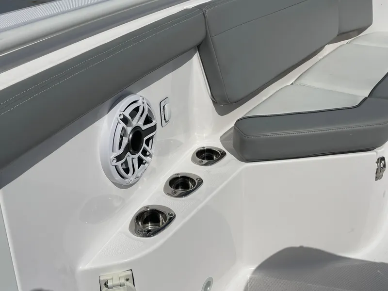 Slide: The Image of 2021 Everglades 395cc boat interior with speaker, cup holders, and cushioned seating. - 10