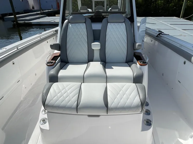 Slide: The Image of Luxury seating on a 2021 Everglades 395cc boat, featuring quilted upholstery and cup holders. - 11