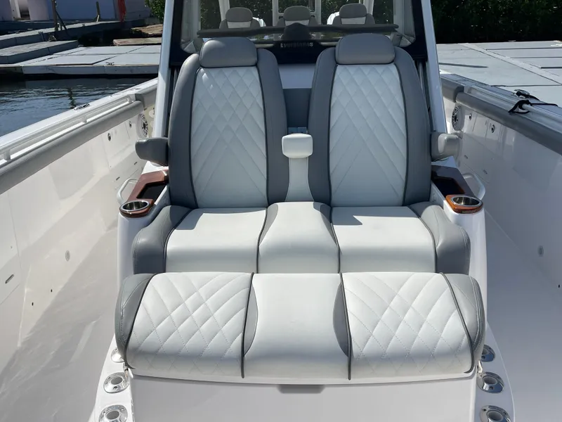 Slide: The Image of Luxury seating on 2021 Everglades 395cc boat, featuring quilted upholstery and cup holders. - 14