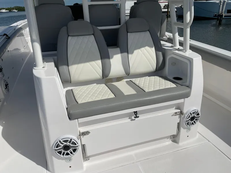 Slide: The Image of 2021 Everglades 395cc boat seating with white and gray upholstery, featuring built-in speakers. - 23