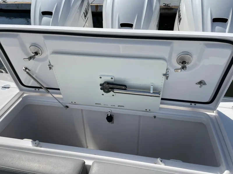 Slide: The Image of Open storage compartment on 2021 Everglades 395cc boat, showcasing interior and engine details. - 25