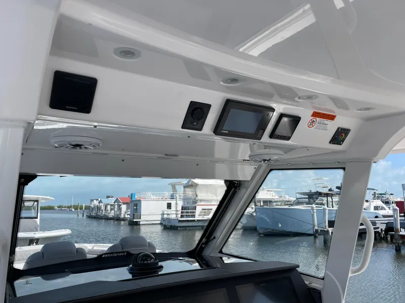 Slide: The Image of Interior view of 2021 Everglades 395cc boat with control panel and marina background. - 28