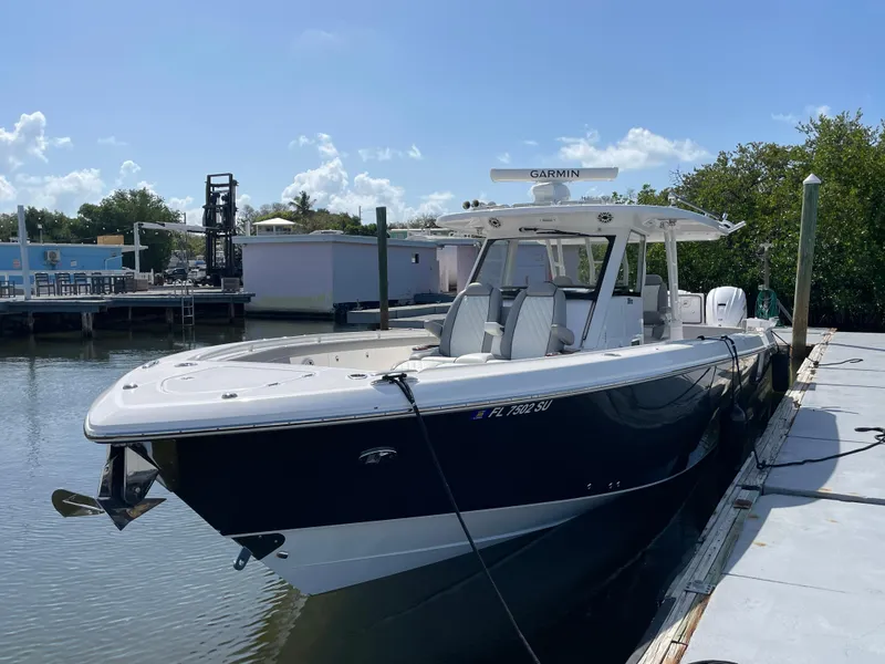 Slide: The Image of 2021 Everglades 395cc boat docked in a marina under a clear blue sky. - 32