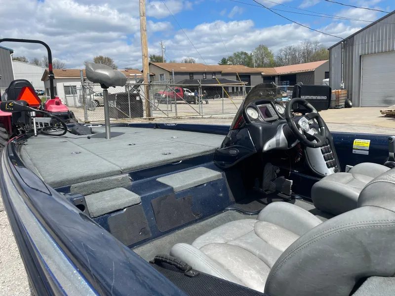 Slide: The Image of 2005 Stratos 200 ProXL boat interior with steering wheel and seating, parked outdoors. - 8