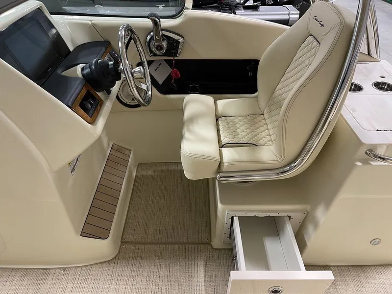 Slide: The Image of 2023 Chris-Craft 24 CALYPSO boat interior with steering wheel and beige seating. - 21