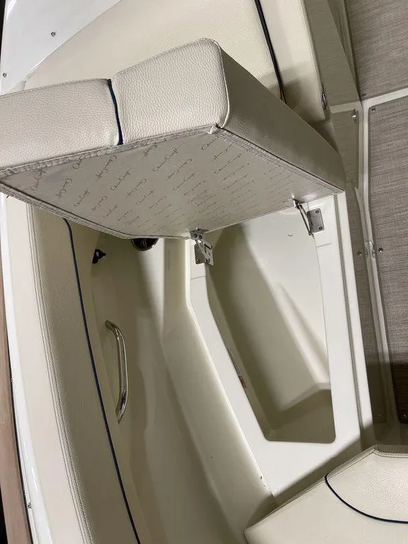 Slide: The Image of 2023 Chris-Craft 24 CALYPSO boat interior with cushioned seating and storage compartment. - 26