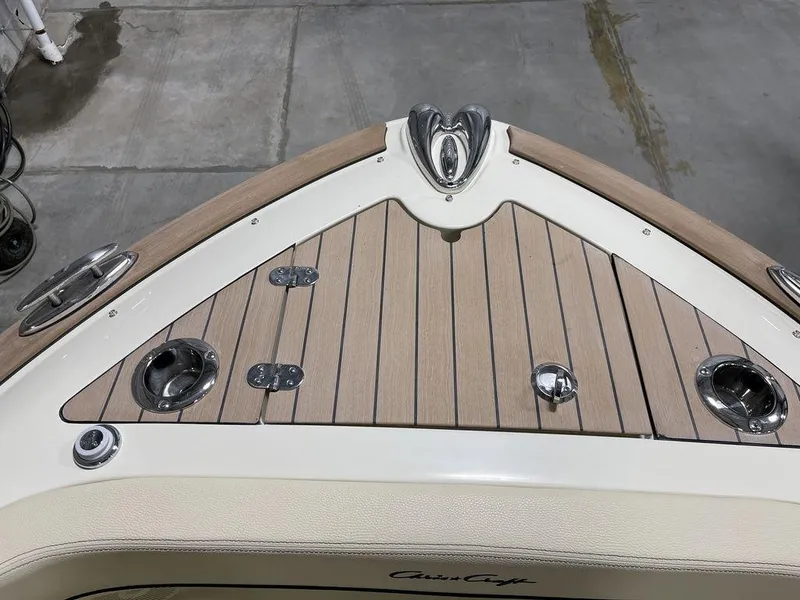Slide: The Image of 2023 Chris-Craft 24 CALYPSO boat deck with wood finish and metal fixtures. - 27