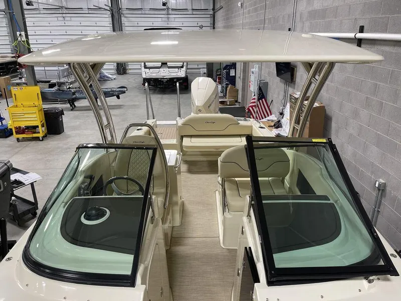 Slide: The Image of 2023 Chris-Craft 24 CALYPSO boat interior with dual consoles and seating, in a garage setting. - 32