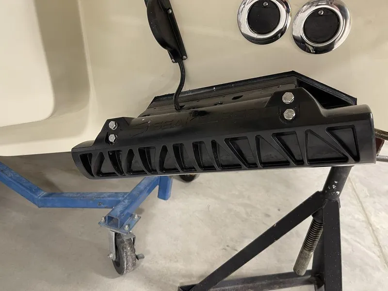 Slide: The Image of 2023 Chris-Craft 24 CALYPSO boat detail with black trim tab and support stand. - 34