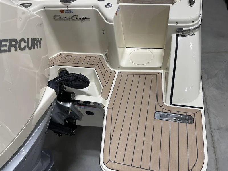 Slide: The Image of 2023 Chris-Craft 24 CALYPSO boat deck with Mercury engine, featuring sleek wood-patterned flooring. - 8