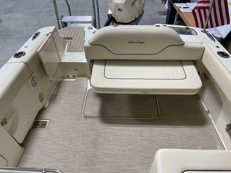 Slide: The Image of 2023 Chris-Craft 24 CALYPSO boat interior with beige seating and carpeted flooring. - 9