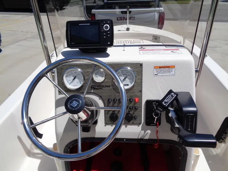 Slide: The Image of 2024 Carolina Skiff EL16JVX boat dashboard with steering wheel and navigation system. - 10