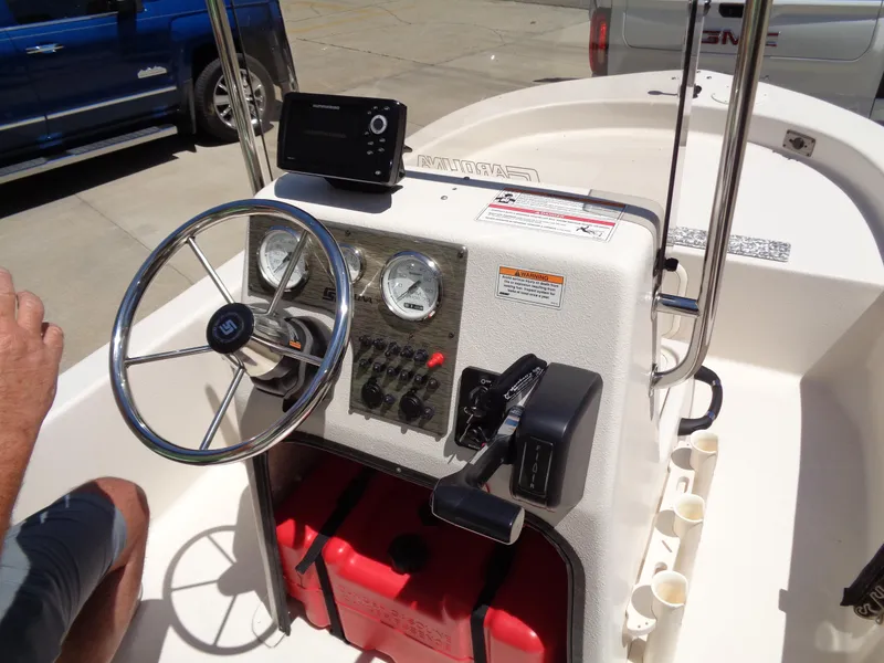 Slide: The Image of 2024 Carolina Skiff EL16JVX boat console with steering wheel and controls. - 11
