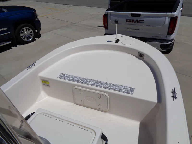 Slide: The Image of 2024 Carolina Skiff EL16JVX boat interior with storage, parked near GMC truck. - 12
