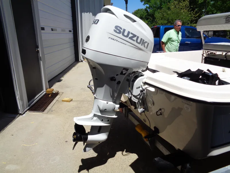 Slide: The Image of 2024 Carolina Skiff EL16JVX boat with Suzuki outboard motor, parked outdoors. - 13