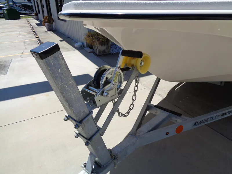 Slide: The Image of 2024 Carolina Skiff EL16JVX boat on trailer, featuring a winch and chain mechanism. - 16