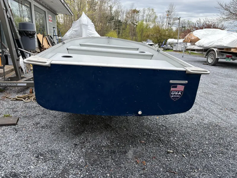Slide: The Image of Duranautic 12 boat, 2021 model, parked on gravel with USA sticker, overcast sky. - 3