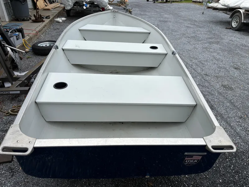 Slide: The Image of 2021 Duranautic 12 boat with three bench seats, parked on gravel. - 5