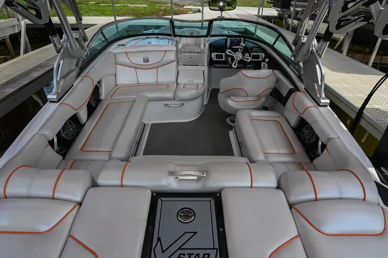 Slide: The Image of 2013 MasterCraft XStar boat interior with luxurious seating and modern dashboard. - 10