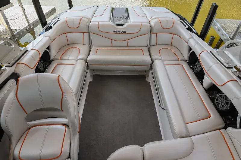 Slide: The Image of 2013 MasterCraft XStar boat interior with white and orange upholstery, spacious seating arrangement. - 12
