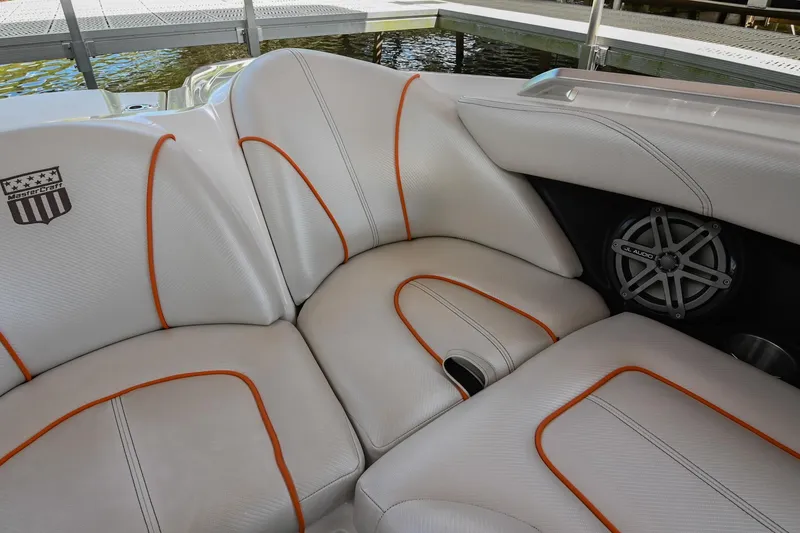 Slide: The Image of 2013 MasterCraft XStar boat interior with white and orange seating, speaker detail. - 33