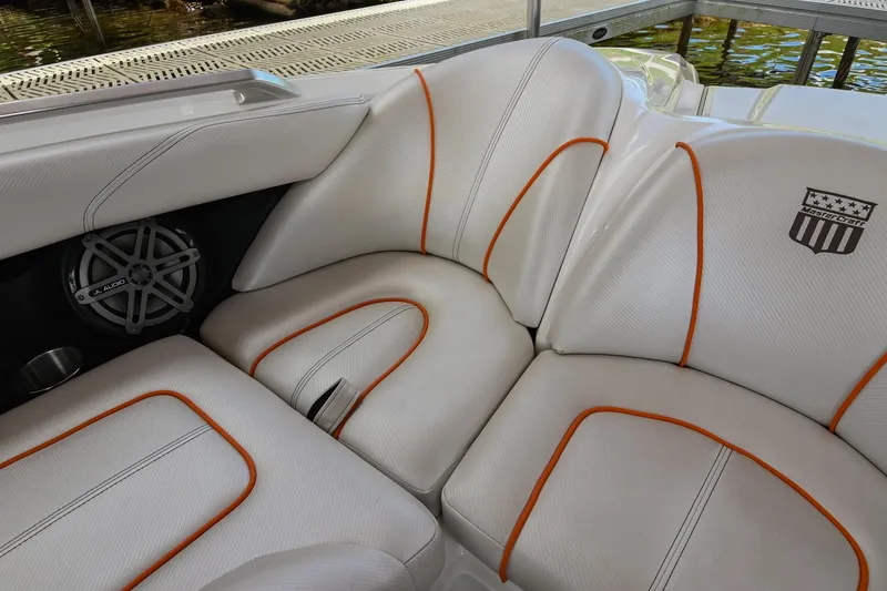 Slide: The Image of 2013 MasterCraft XStar boat interior with white leather seats and orange accents. - 34