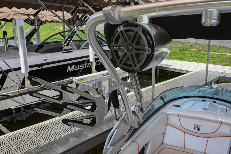 Slide: The Image of 2013 MasterCraft XStar boat with speaker and wakeboard rack at dock. - 38