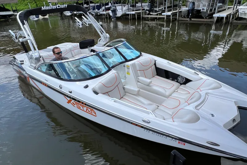 Slide: The Image of 2013 MasterCraft XStar boat on water, featuring sleek design and comfortable seating. - 5
