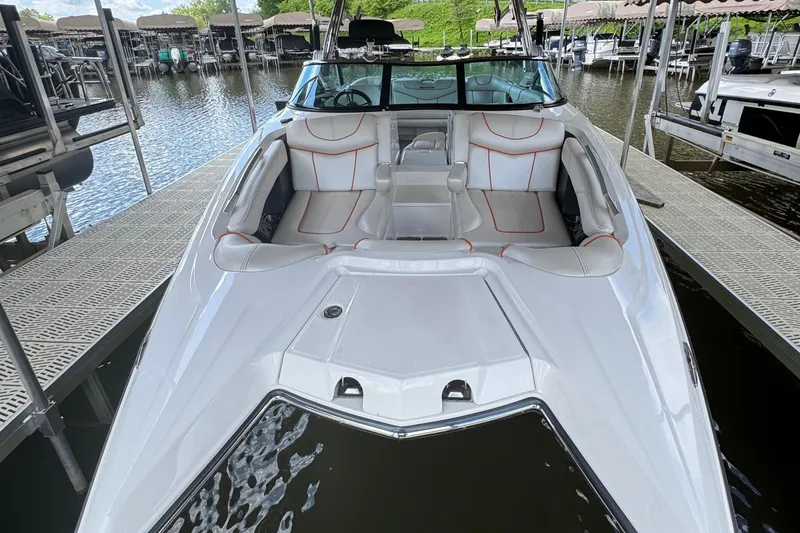 Slide: The Image of 2013 MasterCraft XStar boat with white and red interior, docked at a marina. - 7