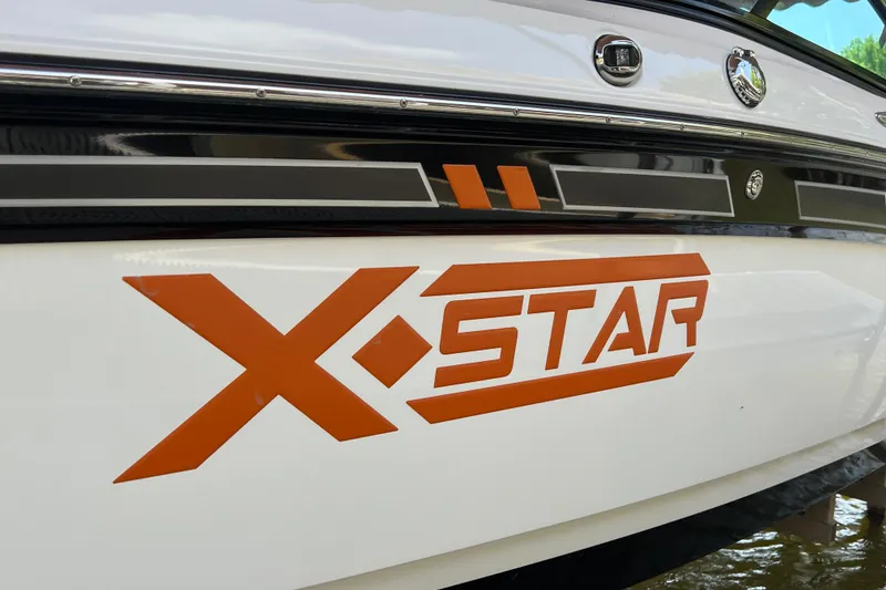 Slide: The Image of 2013 MasterCraft XStar boat with bold orange logo on white hull. - 8