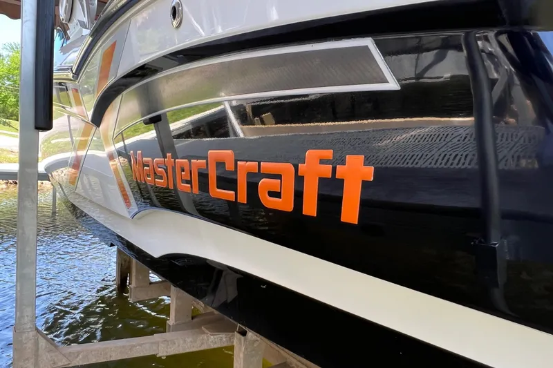 Slide: The Image of 2013 MasterCraft XStar boat with bold orange branding on the side. - 9