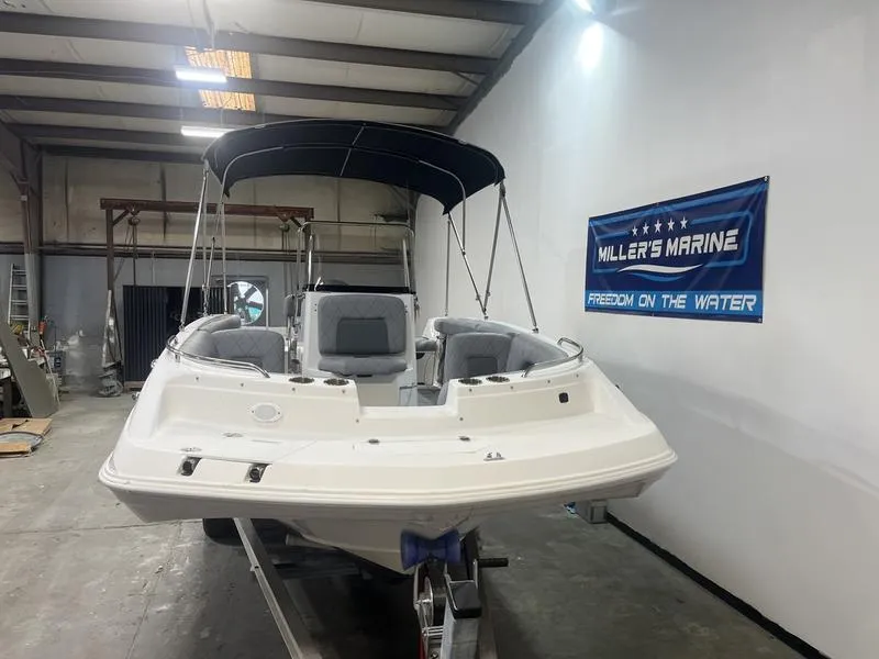 Slide: The Image of 2017 Hurricane 19 CC boat in showroom, featuring canopy and seating, with "Miller's Marine" banner. - 2