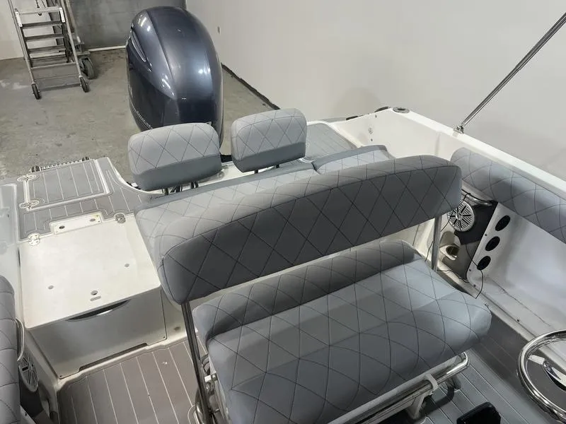 Slide: The Image of 2017 Hurricane 19 CC boat interior with gray seating and outboard motor. - 5