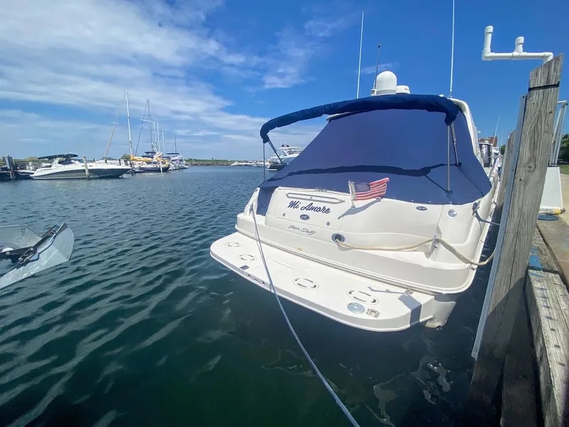 Slide: The Image of 2001 Sea Ray 460 Sundancer yacht docked in a marina under a clear blue sky. - 13