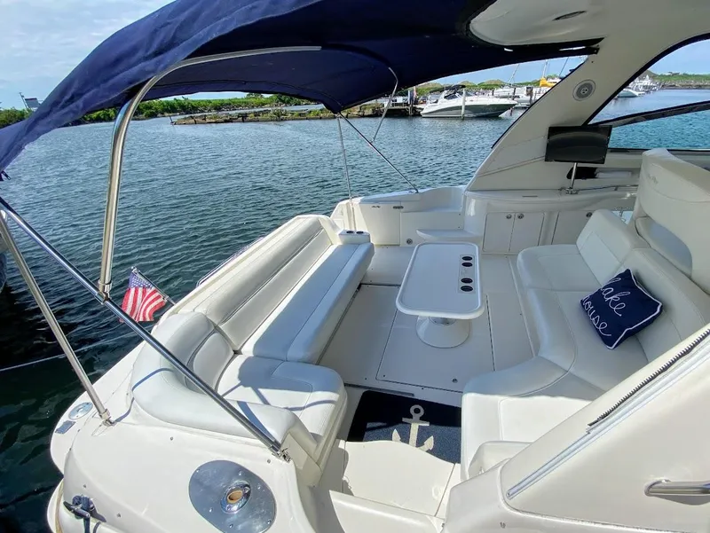 Slide: The Image of 2001 Sea Ray 460 Sundancer yacht with spacious seating and table, docked by the water. - 18