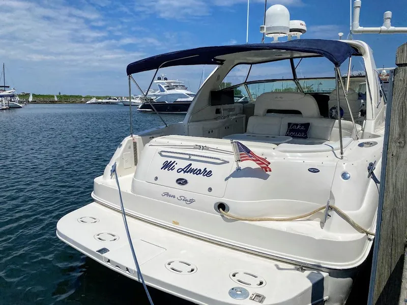 Slide: The Image of 2001 Sea Ray 460 Sundancer yacht docked, featuring a sleek design and American flag. - 3