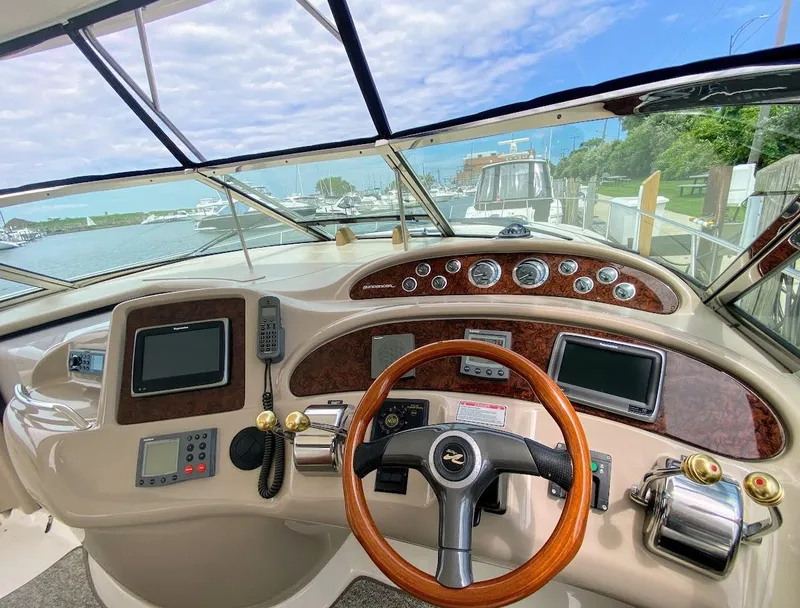 Slide: The Image of Helm of 2001 Sea Ray 460 Sundancer with wood accents and modern navigation equipment. - 33