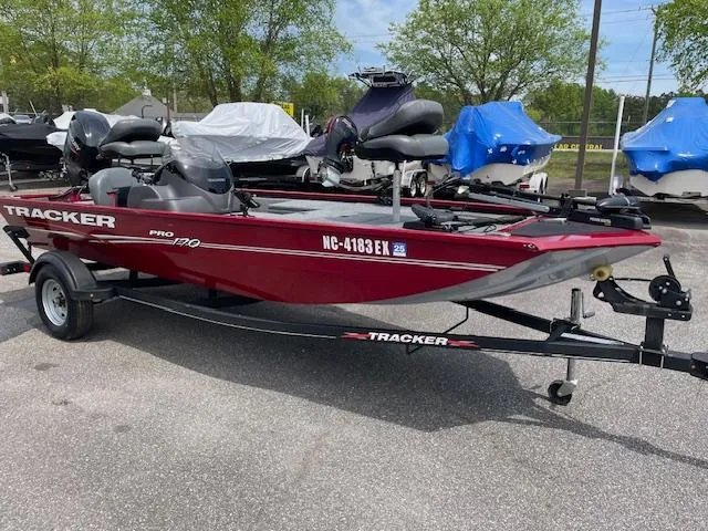 Slide: The Image of 2022 Tracker PRO170 boat on trailer, red color, parked outdoors. - 2