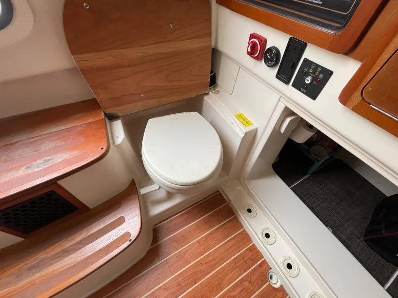Slide: The Image of 2018 Grady-White Canyon 376 boat interior with wooden flooring and compact marine toilet. - 11