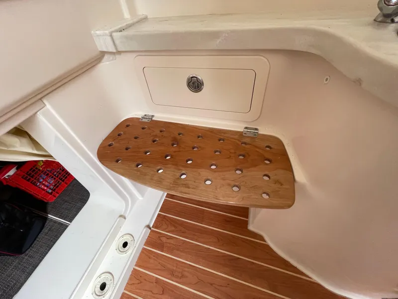 Slide: The Image of 2018 Grady-White Canyon 376 boat interior with wooden foldable seat and storage compartment. - 12