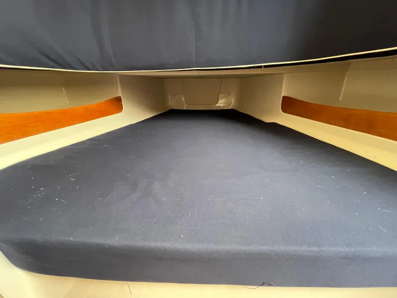 Slide: The Image of 2018 Grady-White Canyon 376 cabin interior with dark bedding and wood accents. - 16