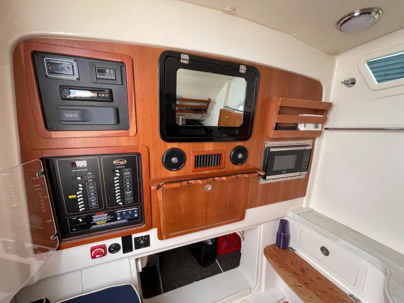 Slide: The Image of 2018 Grady-White Canyon 376 cabin interior with control panel and storage. - 18