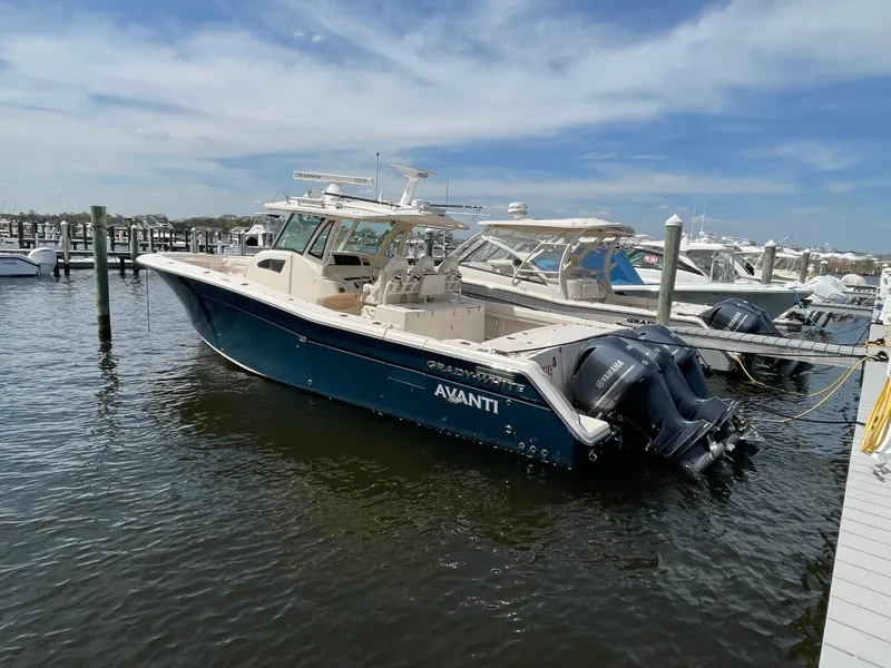 Slide: The Image of 2018 Grady-White Canyon 376 boat docked, featuring triple outboard engines. - 2