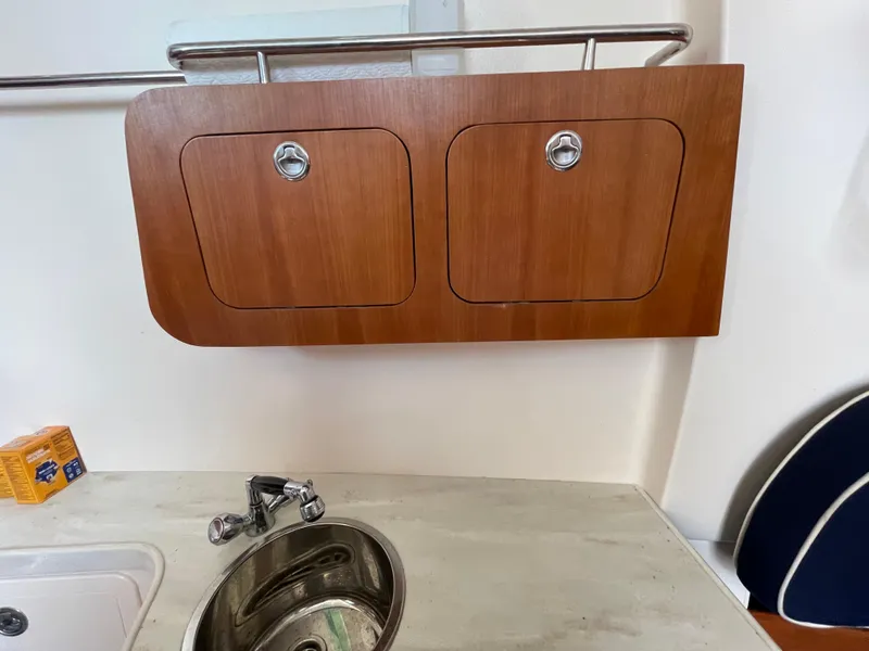 Slide: The Image of 2018 Grady-White Canyon 376 interior with wooden cabinets and stainless steel sink. - 21