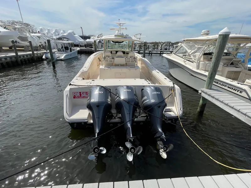 Slide: The Image of 2018 Grady-White Canyon 376 boat with triple engines docked, for sale sign visible. - 4