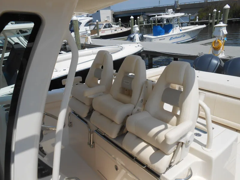 Slide: The Image of 2018 Grady-White Canyon 376 boat with three cushioned seats at a marina. - 43
