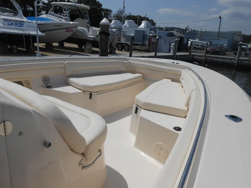 Slide: The Image of 2018 Grady-White Canyon 376 boat interior with cushioned seating at a marina. - 6