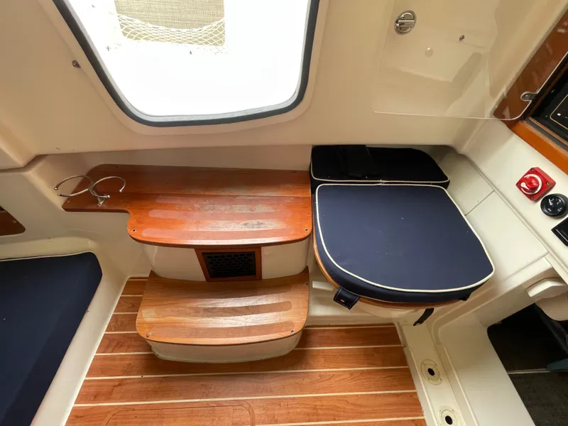 Slide: The Image of 2018 Grady-White Canyon 376 interior with wooden steps and cushioned seating. - 9