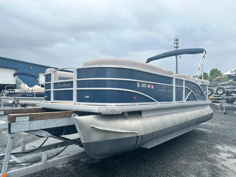 Slide: The Image of 2015 Godfrey Sweetwater 20PE pontoon boat on trailer, parked outdoors under cloudy sky. - 0