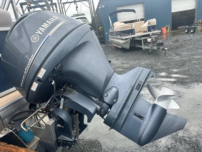 Slide: The Image of Outboard motor on a 2015 Godfrey Sweetwater 20PE pontoon boat in a wet, industrial setting. - 14